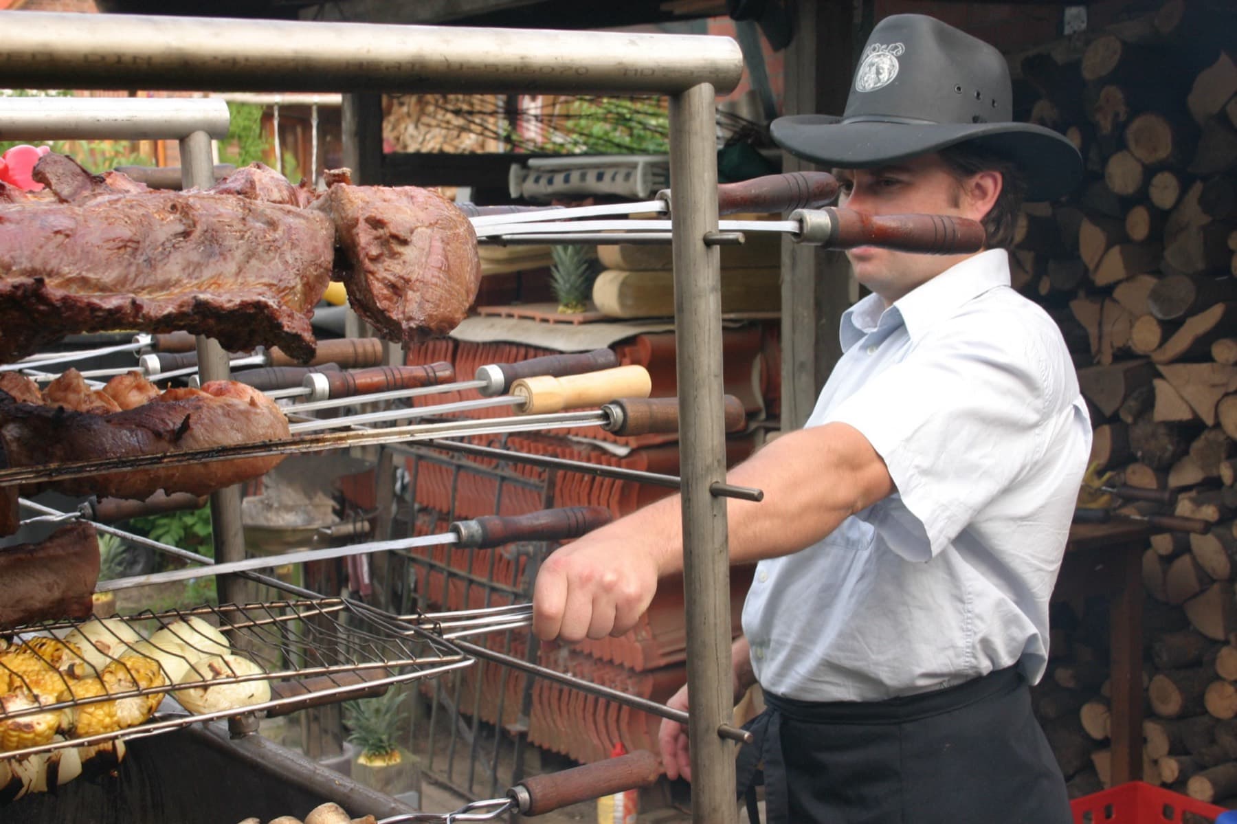 Jair Heck am Spießgrill mit Fleisch und Maiskolben