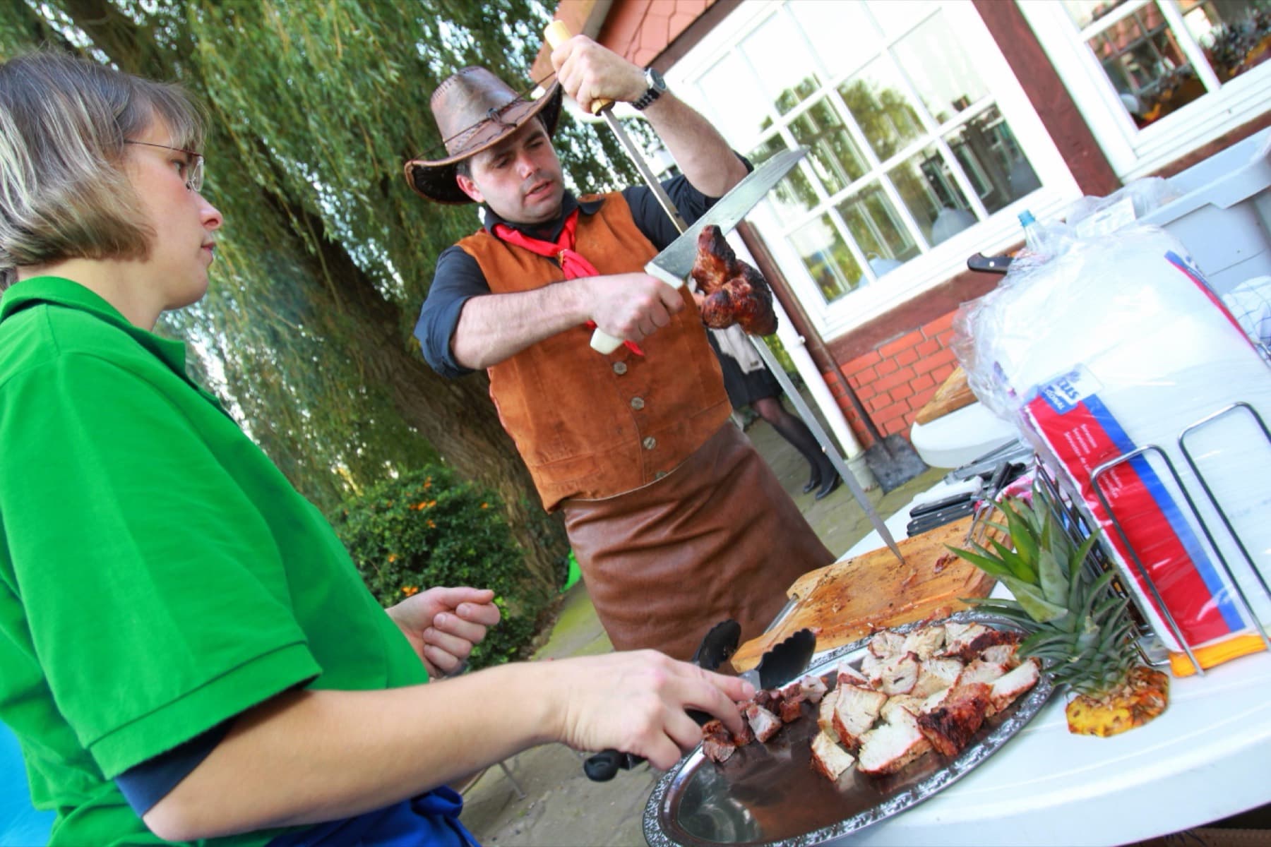 Fleisch wird auf einer Silberhochzeit vom Spieß auf die Platte geschnitten